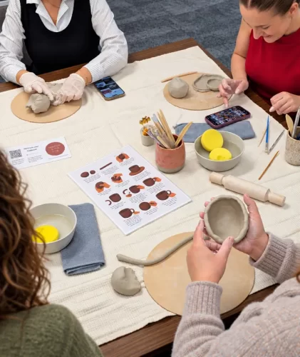 Team members creating with clay during a corporate pottery workshop in Melbourne